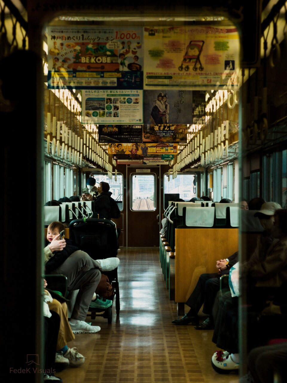 Passengers sitting quietly along the windows of a warmly lit train carriage.